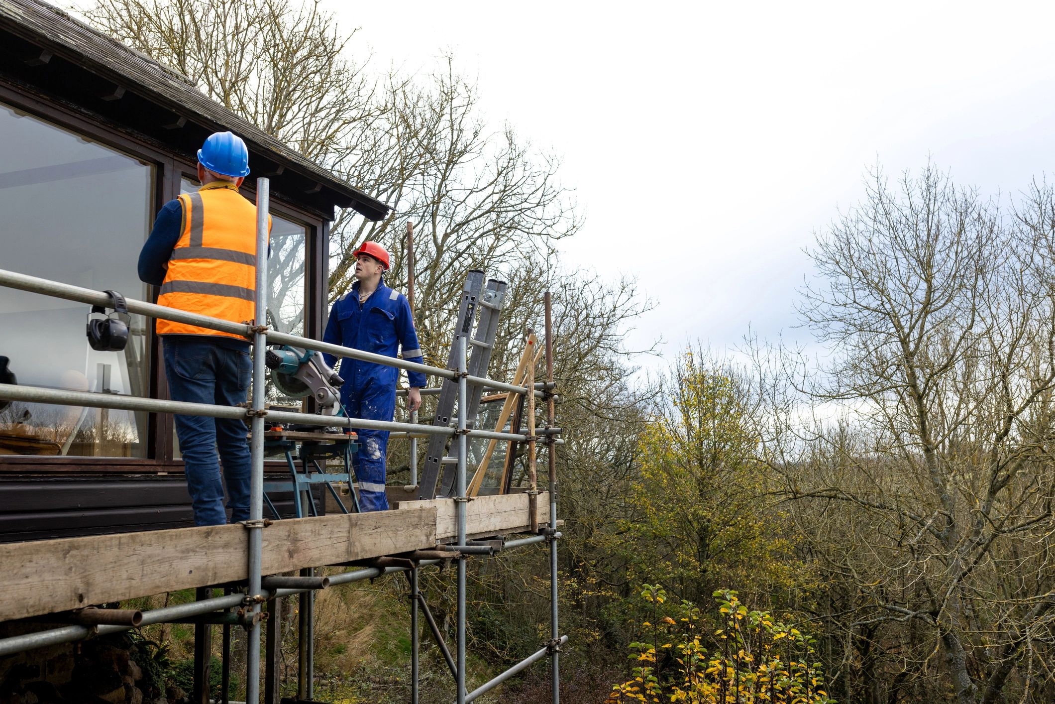 Construction workers inspecting work on a scaffolding platform