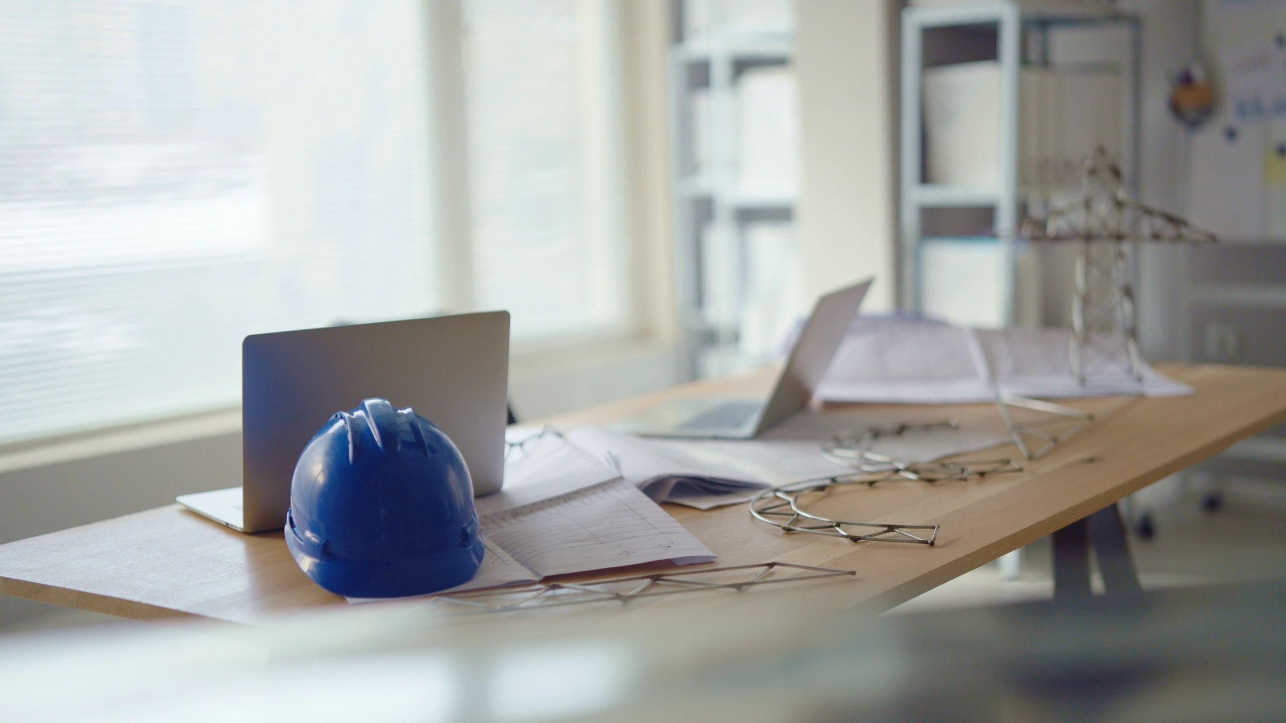 Office desk with computer and construction hard hat